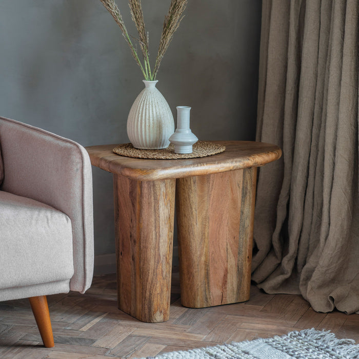 Unusual side table featuring chunky legs and top, with soft flowing curves which soften the look, to create a beautiful sturdy piece. It is crafted from solid mango wood with a natural finish to show the stunning grain of the timber. 
